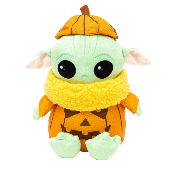 Plush dog toy resembling a Baby Yoda with a pumpkin design, predominantly orange and green, with a cute expression and a scarf.